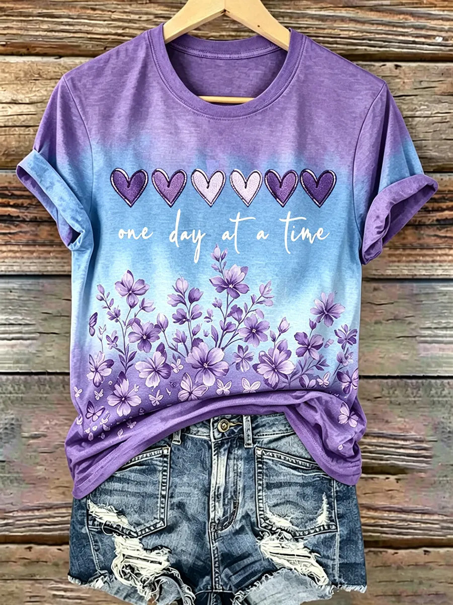 Damen-T-Shirt mit lila Blumenmuster und Aufdruck zur Sensibilisierung für Alzheimer