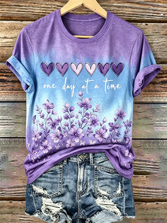Damen-T-Shirt mit lila Blumenmuster und Aufdruck zur Sensibilisierung für Alzheimer