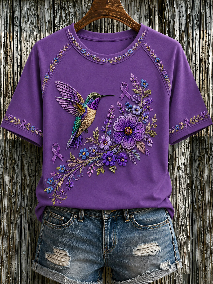 Damen-T-Shirt in Lila mit Blumen- und Kolibri-Print zur Sensibilisierung für die Alzheimer-Krankheit